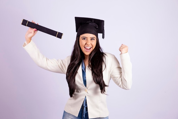 Foto tema educacional estudante de graduação segura um canudo com o certificado de conclusão jovem segurando diploma