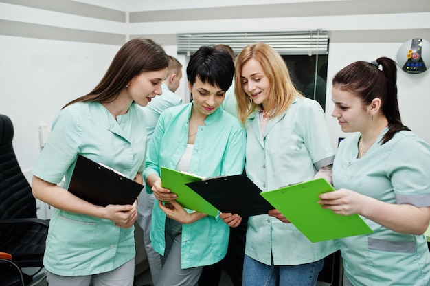 Tema médico. Sala de observação com tomógrafo computadorizado. O grupo de médicas com pranchetas encontrando-se no consultório da ressonância magnética no centro de diagnóstico do hospital.