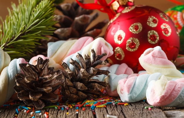 Tema de navidad. Bola de pino y rojo sobre mesa de madera