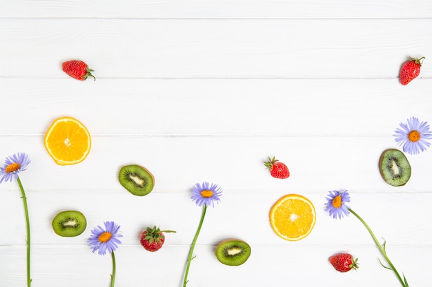 Tema de verano, frutas y flores en una pizarra blanca