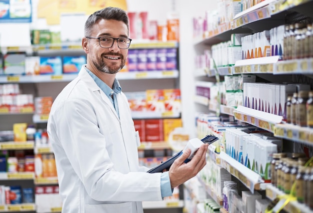 Foto temos uma nova gama de ações em retrato de um farmacêutico maduro fazendo inventário em uma farmácia