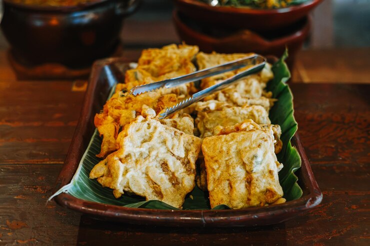 Tempe frito y tahu en un plato de arcilla Alimento condimentado tradicional indonesio