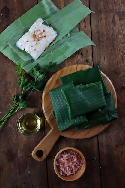 Tempe oder Tempeh eingewickelt in Bananenblätter und Scheiben Tempe ist ein traditionelles indonesisches Essen