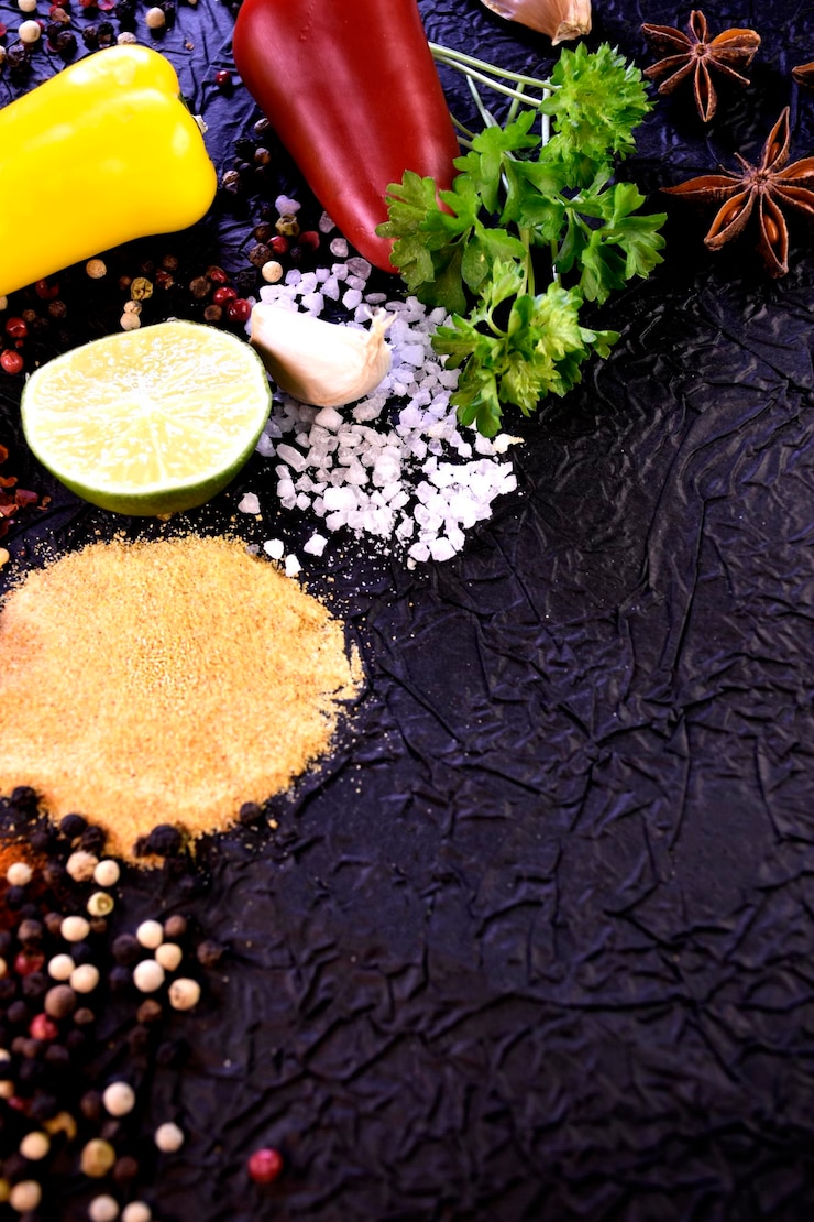 Foto tempero para cozinhar pimenta sal alho salsa sobre um fundo preto ingredientes para dar sabor fo