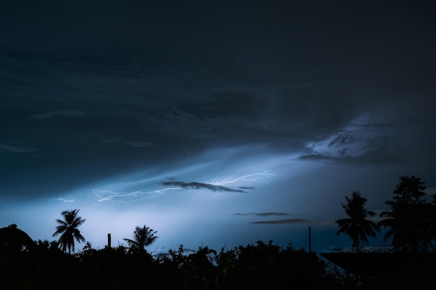 Tempestade de relâmpagos dramáticos no céu noturno sobre a paisagem rural
