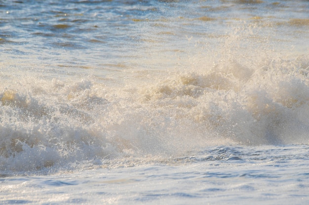 Foto tempestade no mar em raios de ondas grandes do sol, spray.