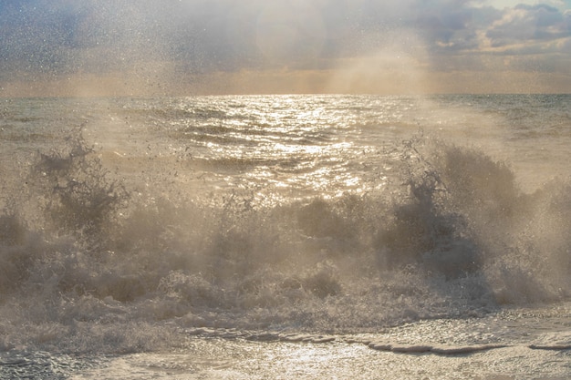 Foto tempestade no mar em raios de ondas grandes do sol, spray.