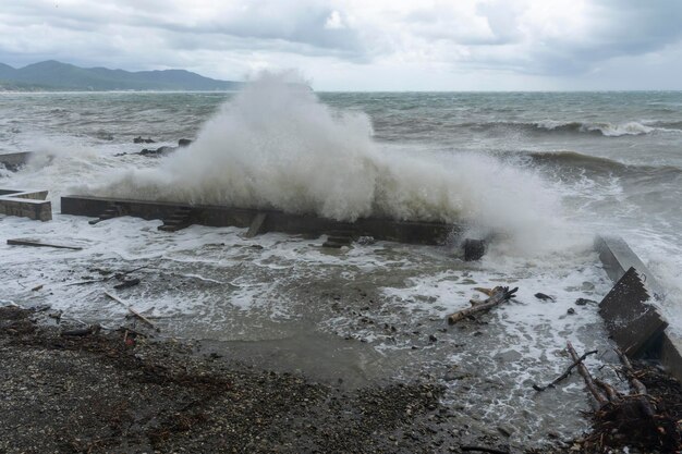 Foto tempestade no mar preto ondas batendo na costa água marrom