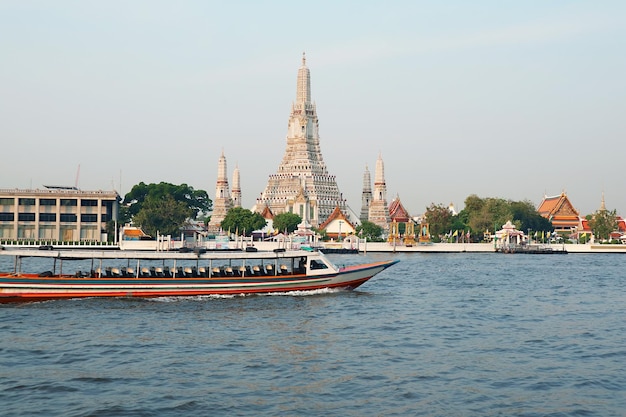 Templo del Amanecer o Wat Arun con el autobús acuático del río Chao Phraya en Bangkok, Tailandia