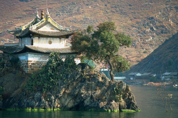 un templo chino en una roca en medio del agua.