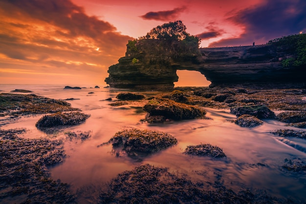 Templo do lote de Tanah no mar no por do sol na ilha de Bali, Indonésia.