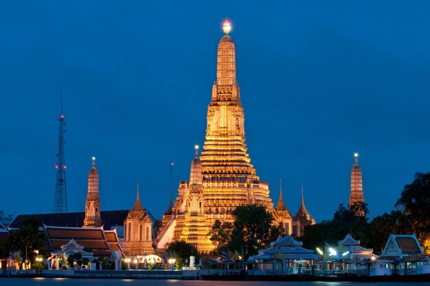 Templo iluminado de wat arun contra el cielo al anochecer