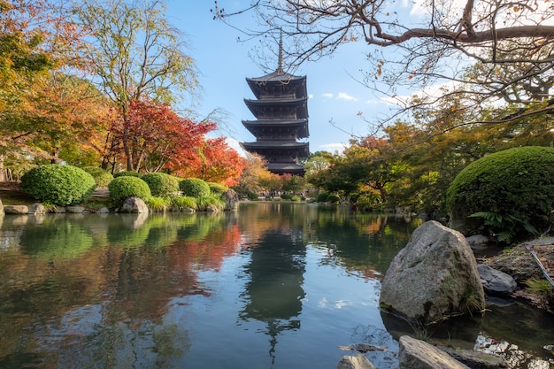 Templo japonés de madera antigua en jardín de hojas de otoño