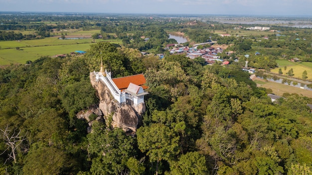 Templo tailandês em uma montanha com árvores verdes