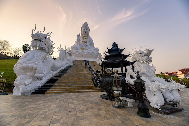 Templo Wat Huay Pla Kang com estátua de Guanyin e dragão e queimador de incenso ao pôr do sol