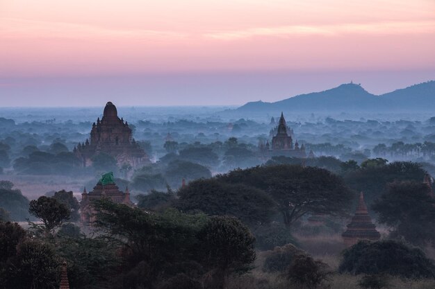 Foto templos contra el cielo durante el amanecer en tiempo de niebla