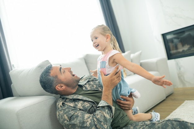 Tempo com o papai. Filha se sentindo envolvida enquanto passava um tempo com o papai voltando para casa após o serviço militar