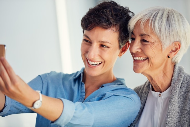 Tempo de selfie significa tempo de sorriso Foto recortada de uma jovem afetuosa tirando uma selfie com sua mãe idosa em casa