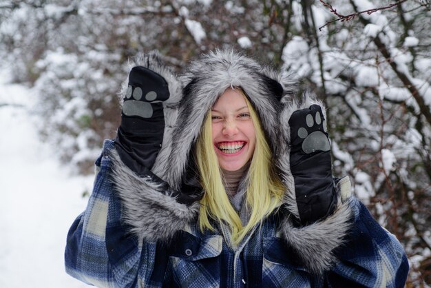 Tempo frio de inverno Natal garota com roupas quentes em winter park garota feliz jogando neve inverno