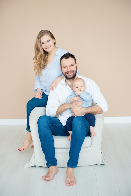 Tempo para a família. Papai e mamãe estão sentados na cadeira com seu filho pequeno