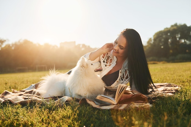 Tempo quente Mulher com seu cachorro está se divertindo no campo em dia ensolarado