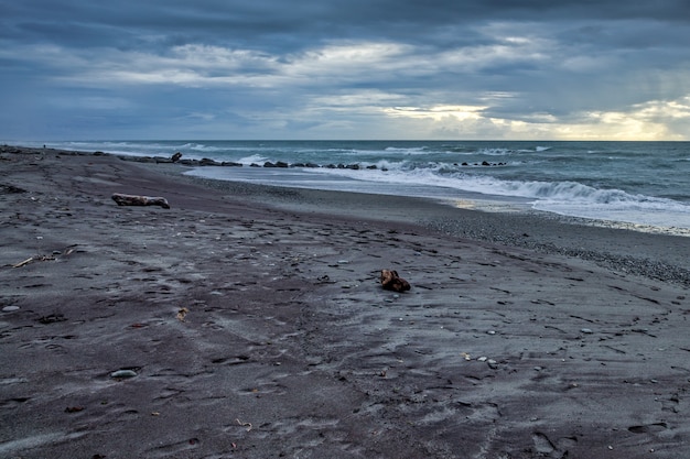 Tempo tempestuoso se aproximando de uma praia deserta na Nova Zelândia