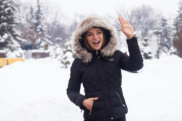 Temporada de inverno e jovem mulher atraente na floresta