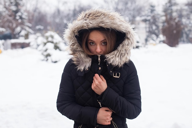 Temporada de inverno e jovem mulher atraente na floresta