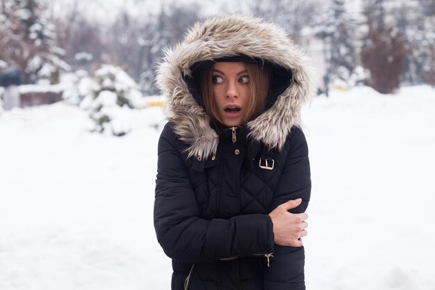 Temporada de inverno e jovem mulher atraente na floresta