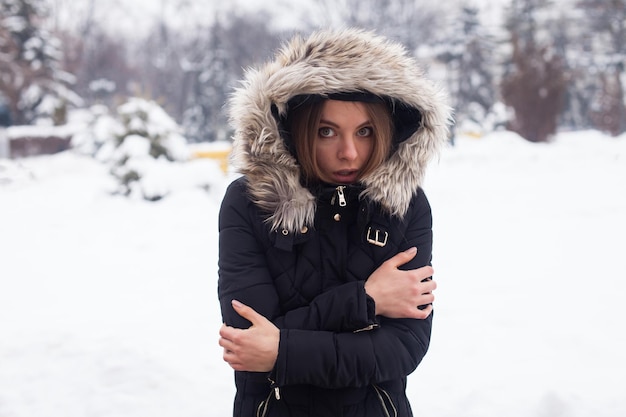 Temporada de inverno e jovem mulher atraente na floresta