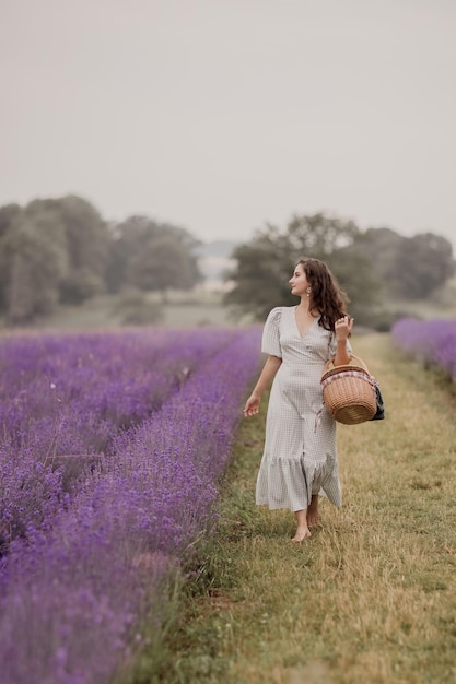 Temporada de verãocampos de lavanda uma garota andando de manhã cedo com uma cesta em campos de lavanda área rural