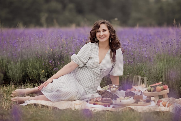 Temporada de verãoCampos de lavanda Uma garota com uma cesta de campo de lavanda Uma mulher desfrutando de um piquenique na natureza