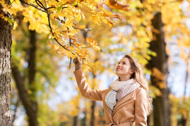 temporada e conceito de pessoas - linda jovem feliz andando no parque outono