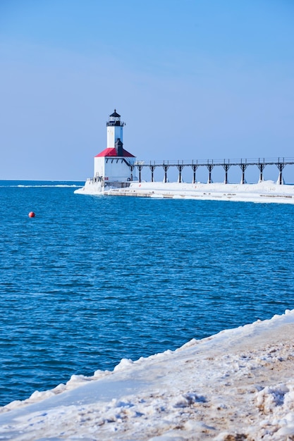 La temporada de invierno faro blanco y rojo en el lago Michigan