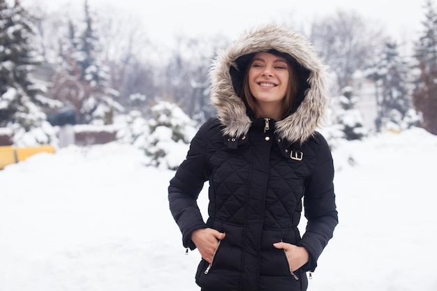 Temporada de invierno y mujer joven y atractiva en el bosque.