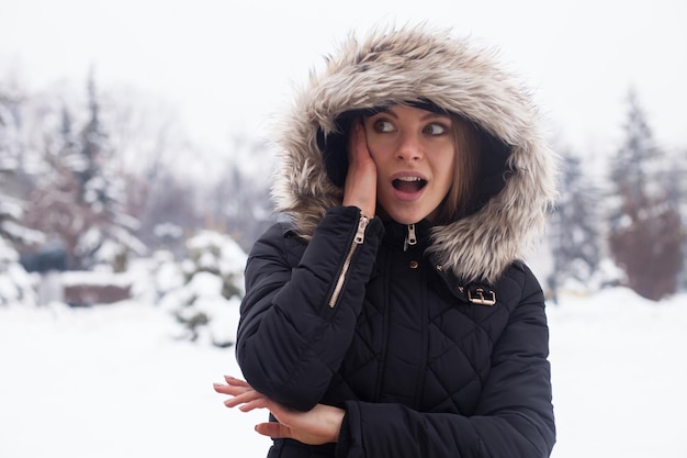 Temporada de invierno y mujer joven y atractiva en el bosque.