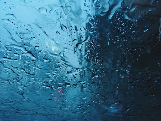 Temporada de lluvias pesadas tono frío frío azul calma tranquila dentro de la vista del coche desde el fondo del vidrio del parabrisas