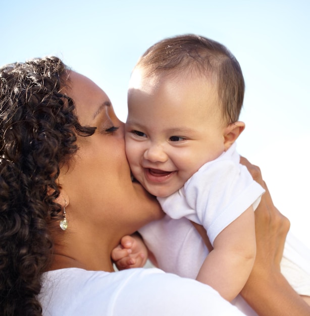 Tempos felizes Close de uma jovem mãe segurando e beijando sua filha bebê