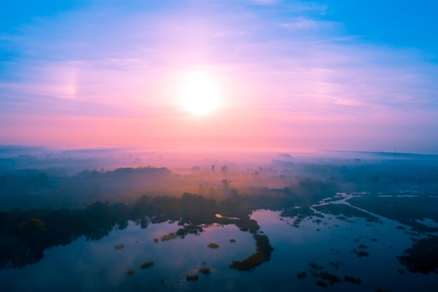 Temprano en la mañana brumosa Vista aérea del campo al amanecer Salida del sol sobre el lago