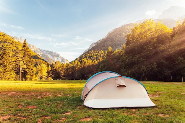 Tenda com incríveis vistas da paisagem da floresta e das montanhas durante o pôr do sol férias de acampamento e férias de verão ao ar livre conceito de estilo de vida