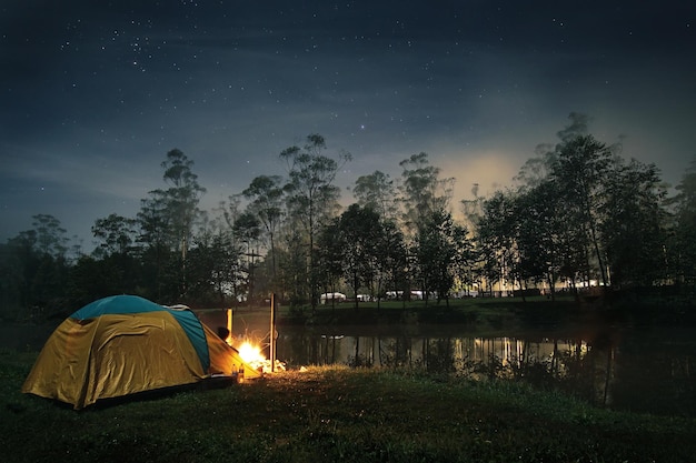 Tenda de acampamento ao lado do lago ao anoitecer