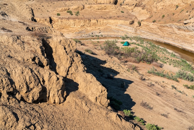 Tenda para turistas em uma área montanhosa e deserta perto de um pequeno rio