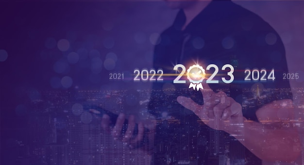 Tendencia de 2023 personas inversionistas comerciales que usan una computadora portátil con un diagrama de año virtual de 2023 cambio de tendencia comercial de 2022 a 2023 estrategia de inversión planificación comercial y concepto de feliz año nuevo