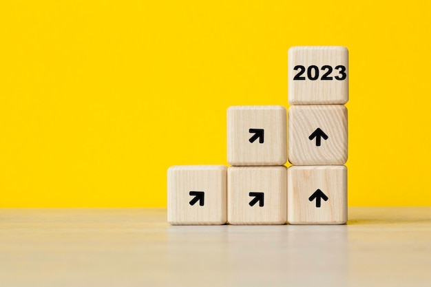 Tendencia de crecimiento de interés de año nuevo 2023 Cubos fondo amarillo Simboliza