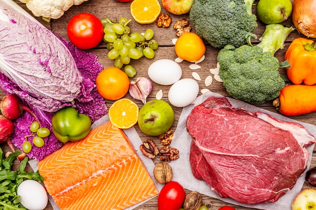Tendencia de la dieta paleo / pegan. Concepto de comida sana y equilibrada. Conjunto de productos frescos, carne cruda, salmón, verduras y frutas.