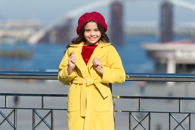 Tendencia de estilo francés. Caminata relajada sin preocupaciones. Beneficios para la salud de caminar. Niña adorable niño caminar fondo desenfocado. Chica de moda disfruta de caminar en un día soleado de primavera. Niño con boina de sombrero brillante y abrigo de abrigo.