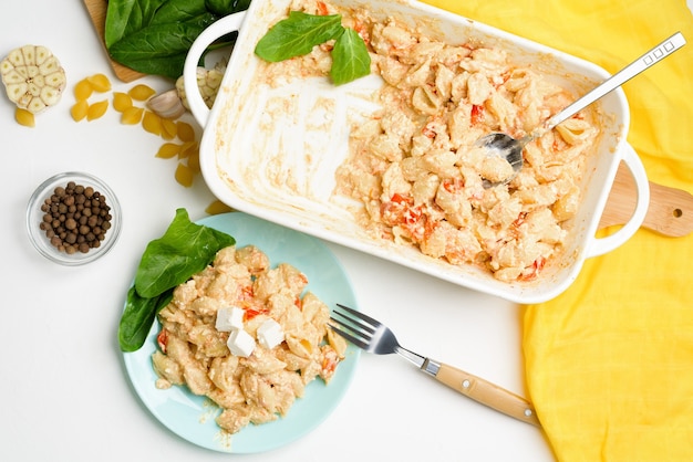 Tendencia queso feta al horno con tomate y pasta, ajo pimiento sobre un fondo claro