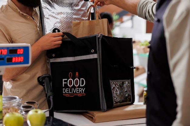 El tendero coloca el pedido en la bolsa de entrega.