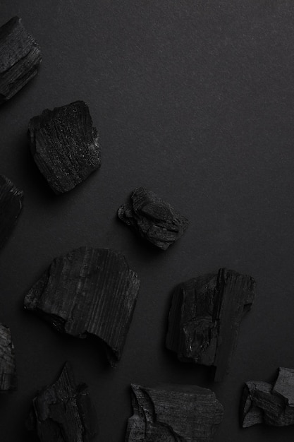 Tendido plano con carbón natural sobre fondo negro
