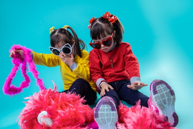 Tendo clima de férias. Meninas adoráveis elegantes com síndrome de down brincando com a decoração para o dia festivo